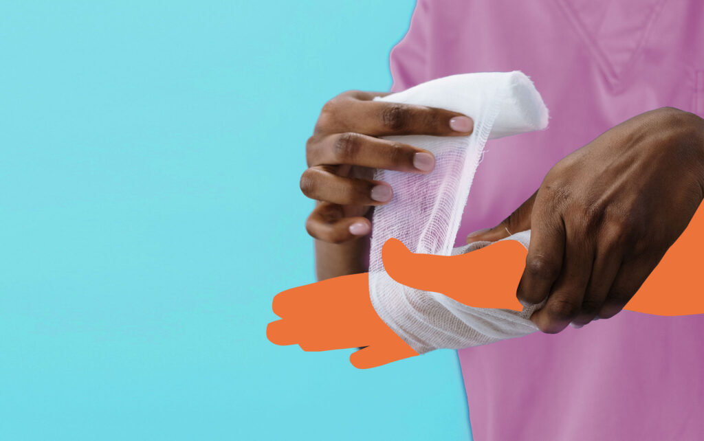 Medical professional wrapping an injury on a hand