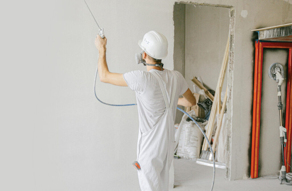 Man Professionally Spray Painting at Work